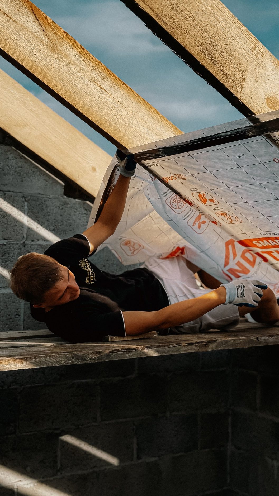 A worker installing roof insulation during a home upgrade